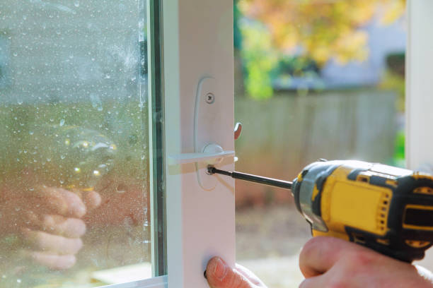 Close-up of a worker installing a sliding door lock with a drill